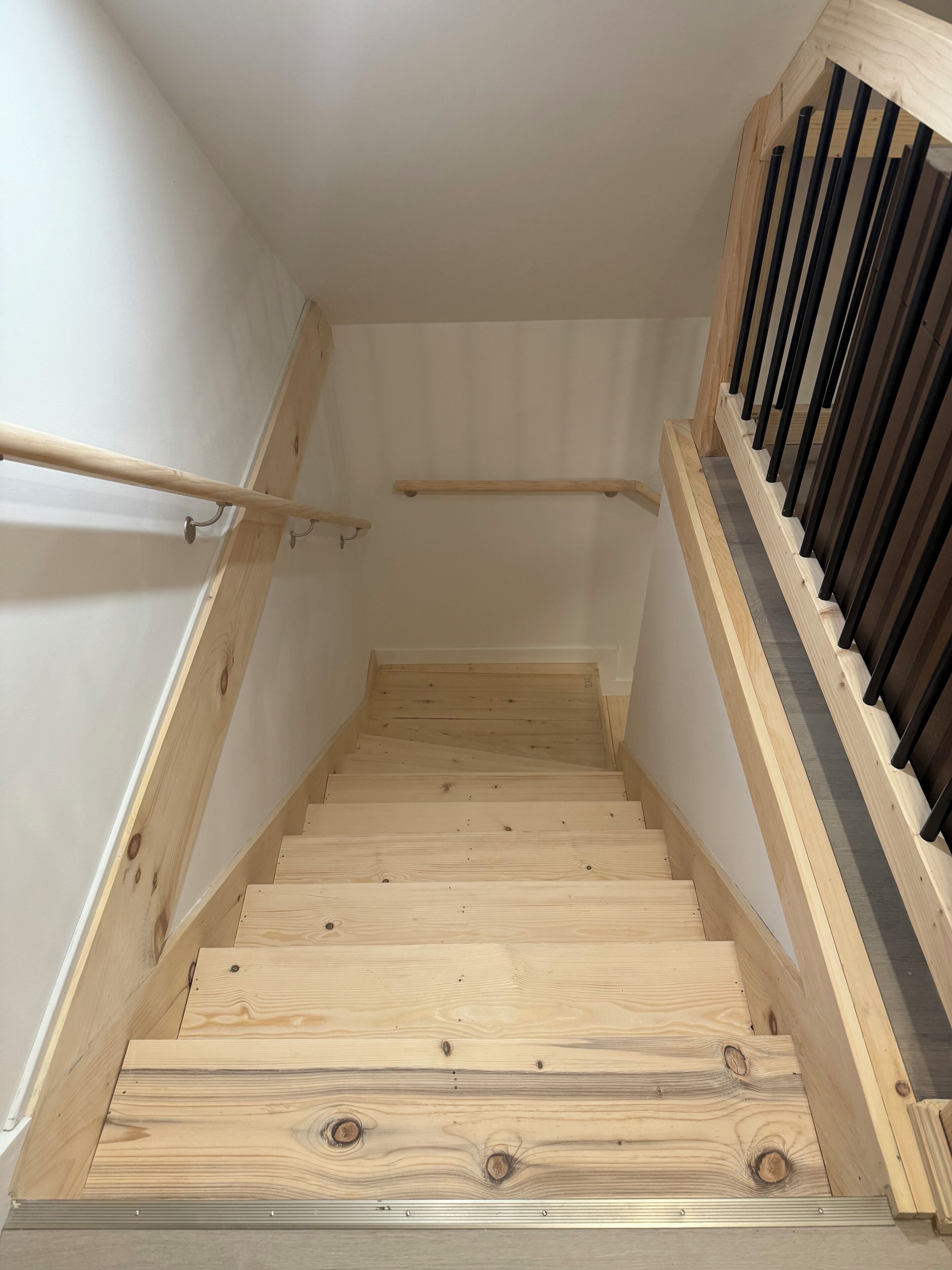 Een houten trap met een leuning aan de linker- en rechterkant.