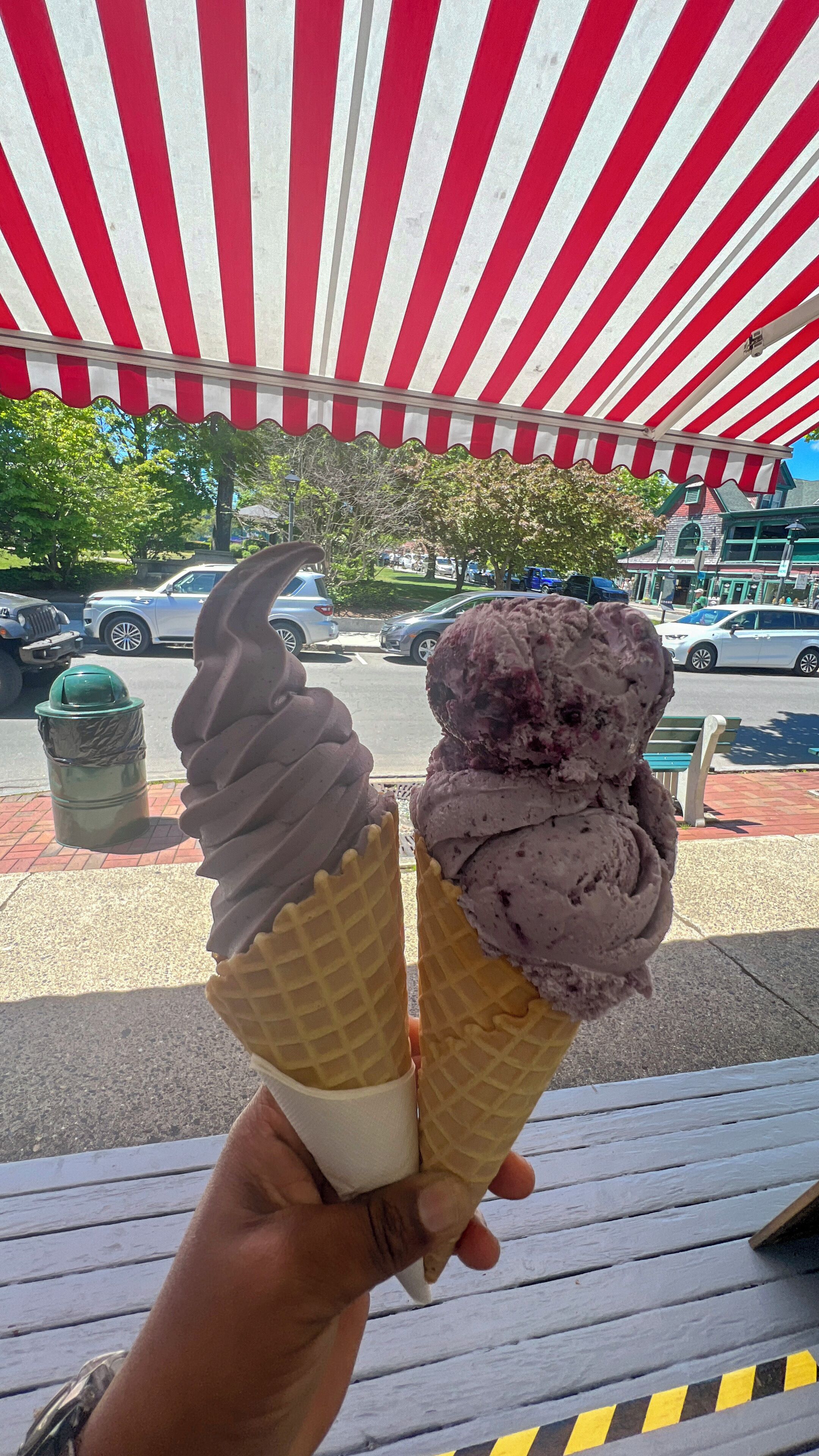 Two ice cream cones held by a person.
