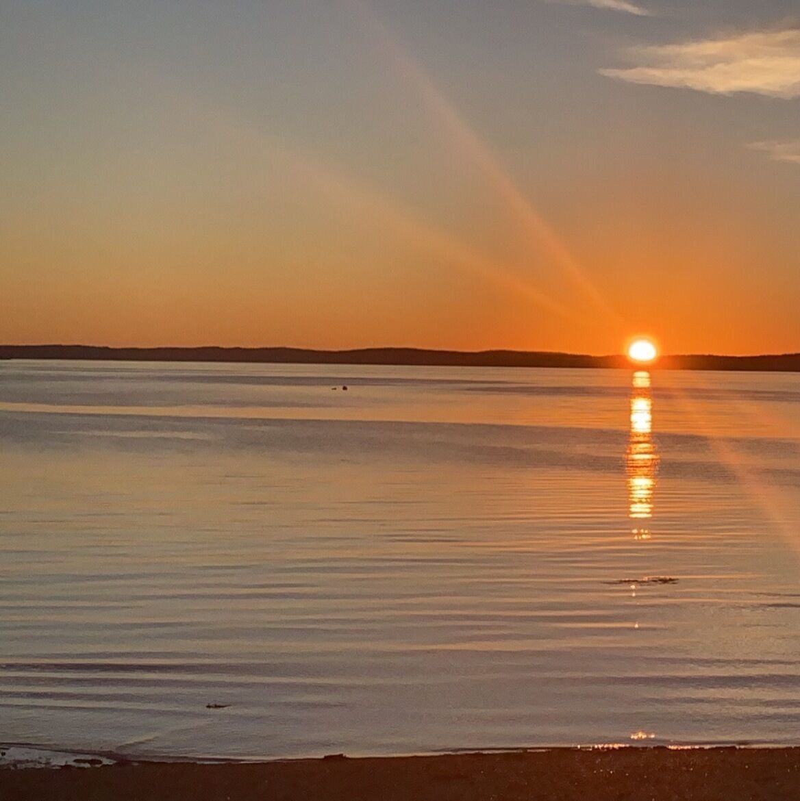 Ruhige Wasserfläche, die die Sonne spiegelt.