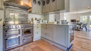 Una cucina moderna con elettrodomestici in acciaio inossidabile, mobili chiari e un'isola centrale.
