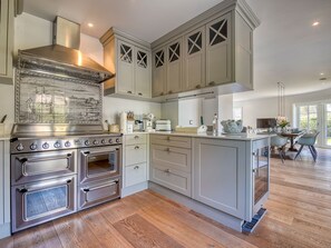 A modern kitchen with stainless steel appliances, light-colored cabinetry, and a central island.