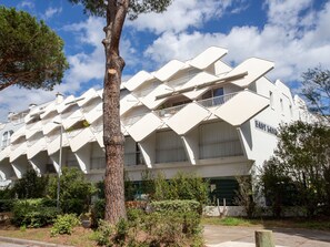 A modern building with a unique geometric facade, labeled "EAST BAND." - East Land by Interhome (La Grande Motte)