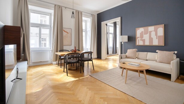 Ein modernes Wohnzimmer mit Sofa, Couchtisch und Essbereich.