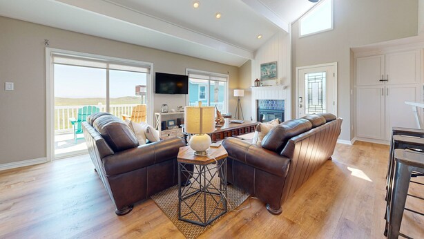 A spacious living room with a large sectional sofa, a coffee table, and a ceiling fan. - Shared Pool, Boardwalk to the Beach, Pet Friendly (Port Aransas)
