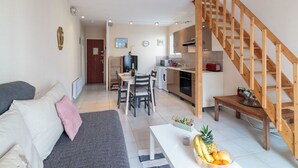Un apartament modern amb saló, cuina i escala.