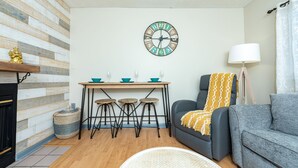 A living room with a fireplace, a sofa, a coffee table, and a wall clock.
