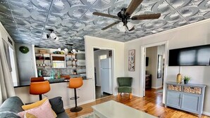 Una sala de estar moderna con un sofá gris, una mesa de centro blanca y un ventilador de techo.
