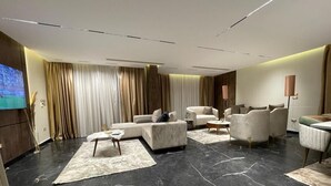 A modern living room with a sectional sofa, armchairs, and a coffee table. - Villa in palm hills-the crown (6th of October City)