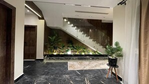 A spacious lobby with a marble floor, a staircase, and potted plants. - Villa in palm hills-the crown (6th of October City)