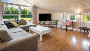A modern living room with a sofa, coffee table, TV, and seating area.