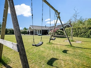 A wooden swing set in a grassy yard with a house in the background. - "Anca" - 450m from the sea by Interhome (Glesborg)