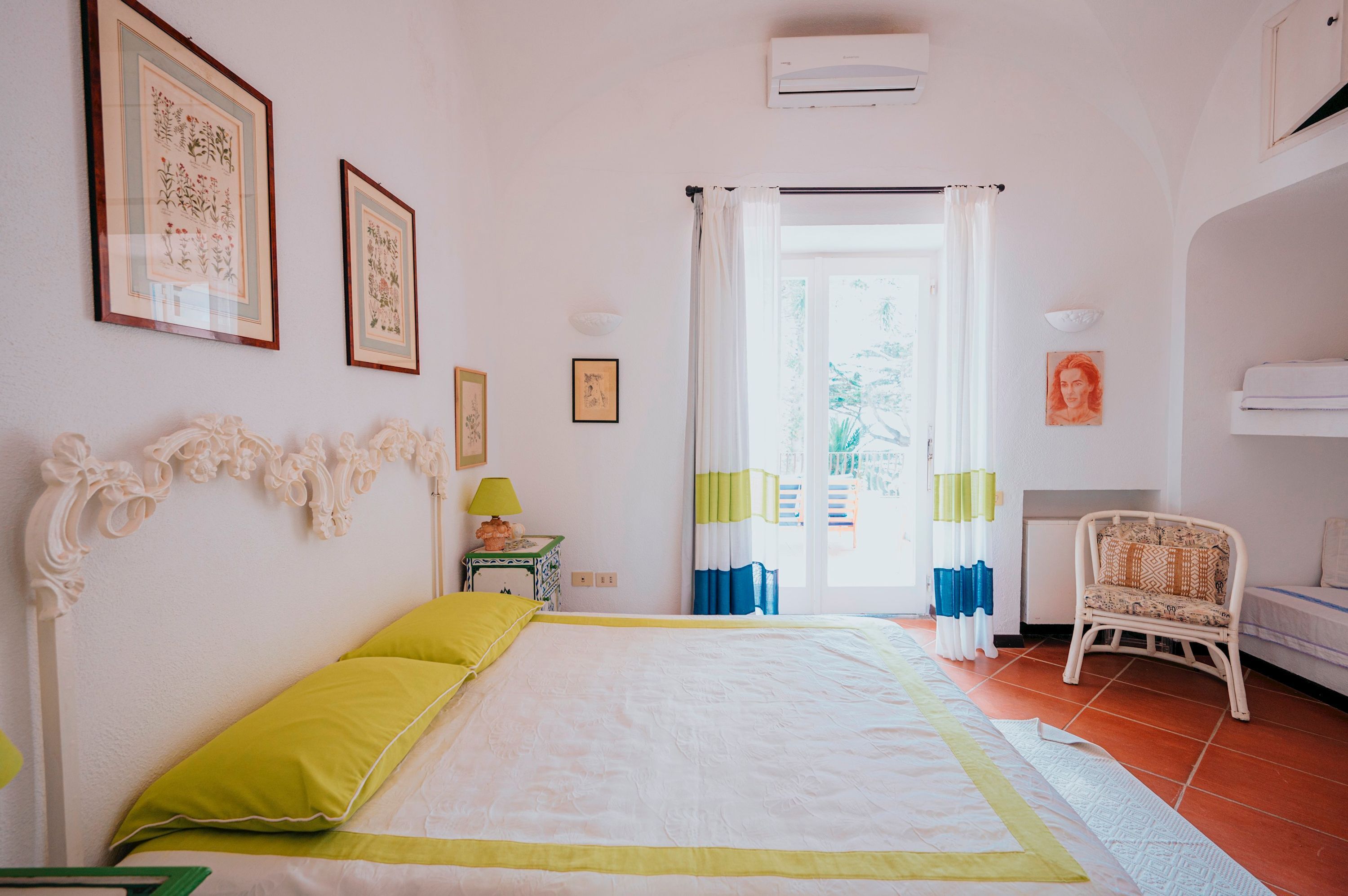 Una camera da letto con un letto, una sedia e una finestra con tende.