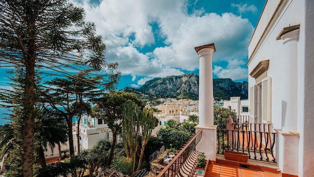 A balcony with a view of a coastal town, a mountain in the background, and a clear sky. - Villa White by Elite Villas (Capri)