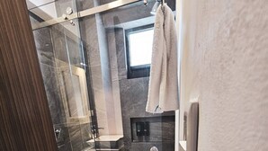 A modern bathroom with a glass shower enclosure, a toilet, and a bathtub. - Centro Expositor, Feria, Estadios, Acuario, Planetario (Heroica Puebla de Zaragoza)