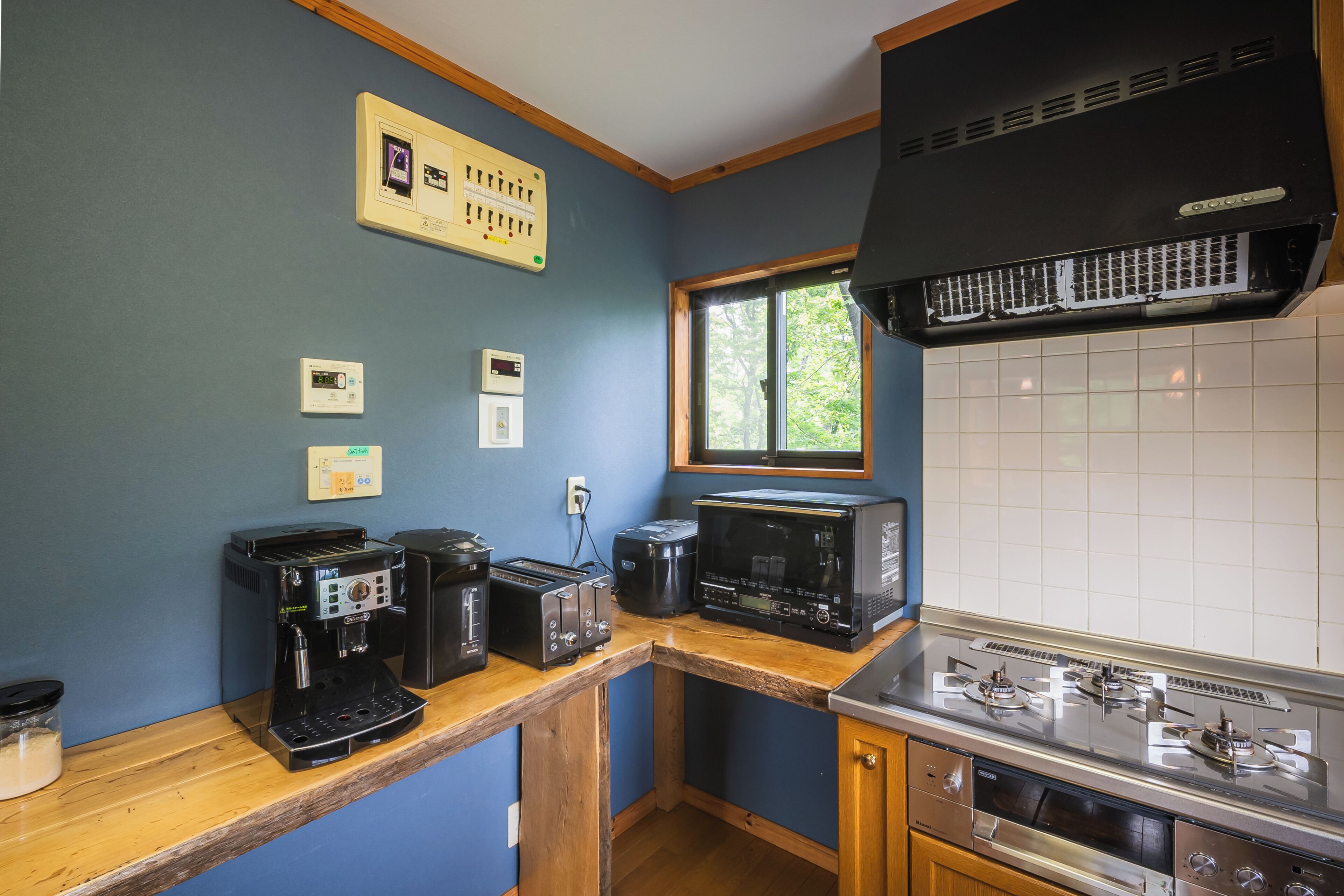 A compact kitchen with a built-in stove, a coffee maker, and a microwave.