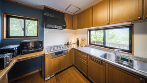 Una cocina compacta con gabinetes de madera, estufa y pileta.