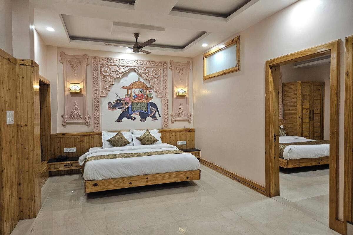 Une chambre à coucher avec un grand lit, une tête de lit en bois, des panneaux décoratifs sur les murs, un ventilateur de plafond et un miroir.
