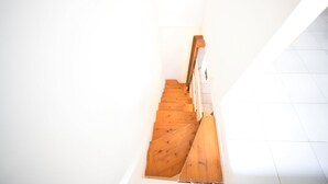 A wooden staircase with white walls and a tiled floor. - Casa Pamalù 5 with pool in the beautiful bay of Nisporto (Rio dell'Elba)
