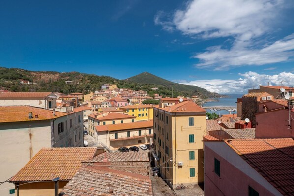 A coastal town with terracotta-roofed buildings, a clear sky, and a distant view of the sea. - Casa al secco apartment with sea view in the heart of Rio Marina (Rio Marina)