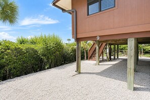 Ein Holzhaus mit einem Schild mit der Nummer 9, einem überdachten Außenbereich und einem Kiesweg.