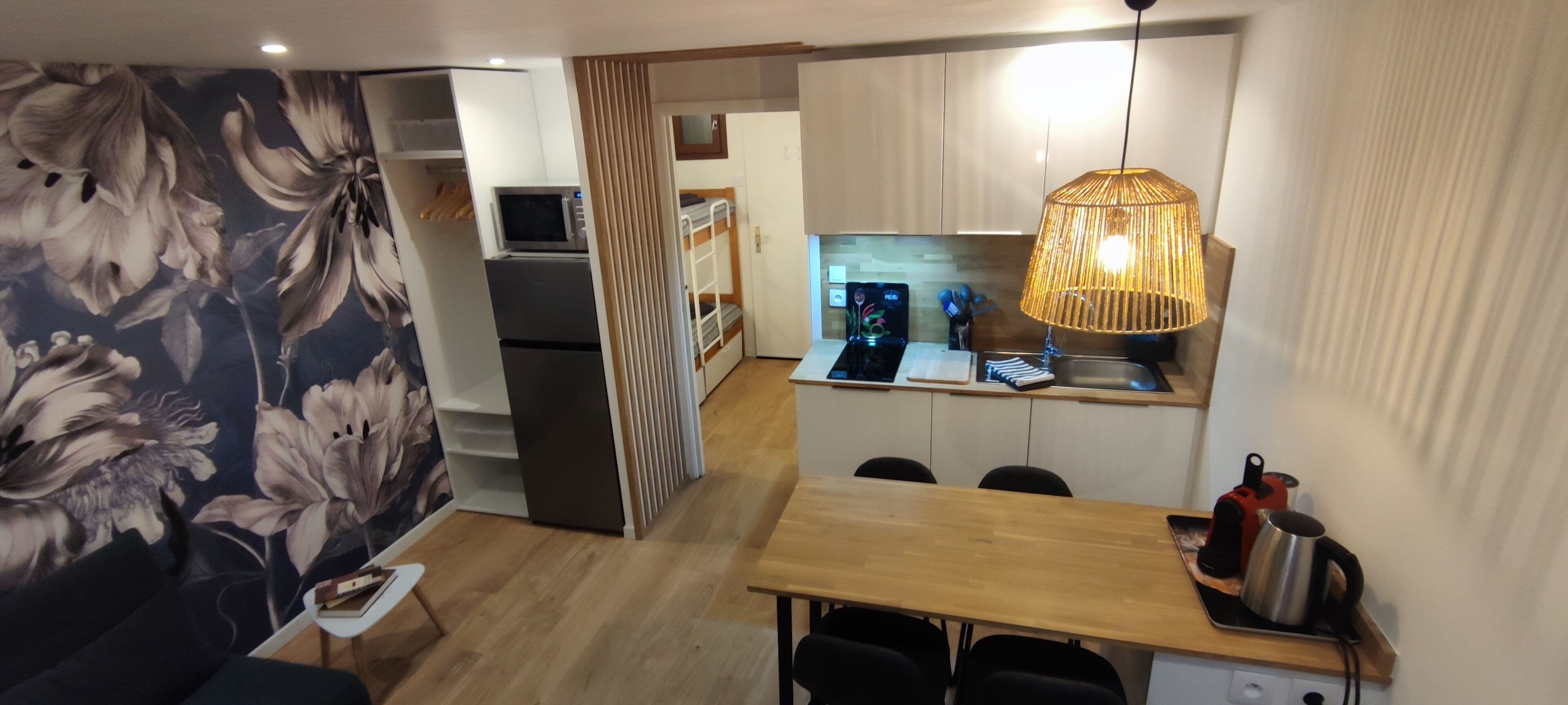 Ein kompakter Wohnbereich mit Küchenzeile, Essbereich und Schlafzimmer.