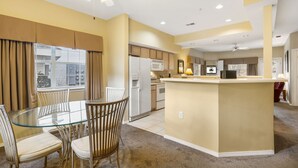 A modern kitchen with a central island, built-in appliances, and a dining area with a glass table and chairs. - Dog Friendly, Discounted Tee Times, Course Views, Near Hwy 76! (Branson)
