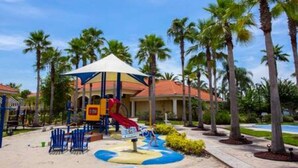 Zona de juegos infantiles con tobogán, asientos y una estructura cubierta.