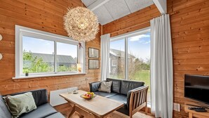 A cozy room with a wooden interior, a sofa set, a dining table, and a TV. - "Oddger" - 250m to the fjord by Interhome (Skjern)