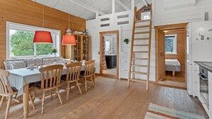 A cozy cabin interior with a dining area, kitchen, and loft space. - "Oddger" - 250m to the fjord by Interhome (Skjern)