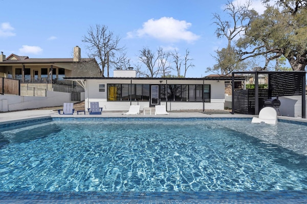 Private pool with lounging chairs and a grill