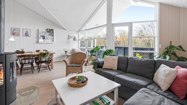A spacious living room with a fireplace, a dining area, and large windows offering natural light and views. - "Ingelis" - 150m to the fjord by Interhome (Tarm)