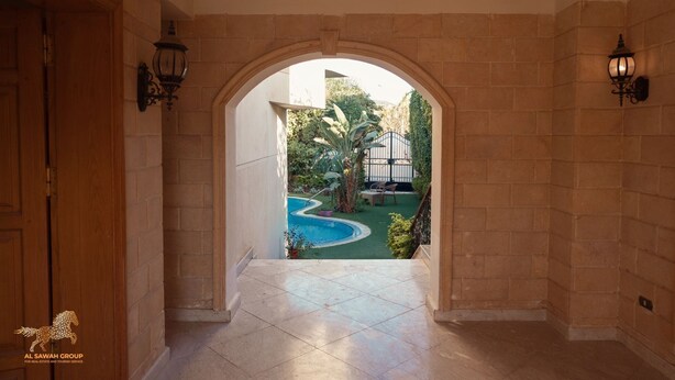 A hallway with a view of a swimming pool and greenery. - villa in deplomaseen district (Sheikh Zayed City)