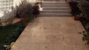 A two-story building with a central entrance, a balcony on the upper floor, and a small garden area with steps leading to the entrance. - villa in deplomaseen district (Sheikh Zayed City)