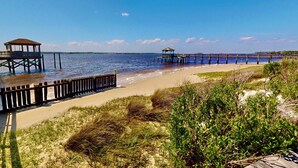 A beach with a wooden pier and two gazebos. - Fantastic Water Views, Pool, Hot Tub, Outdoor Kitchen, Fishing Dock, Waterfront Updated Home, DogsOK (Wilmington)