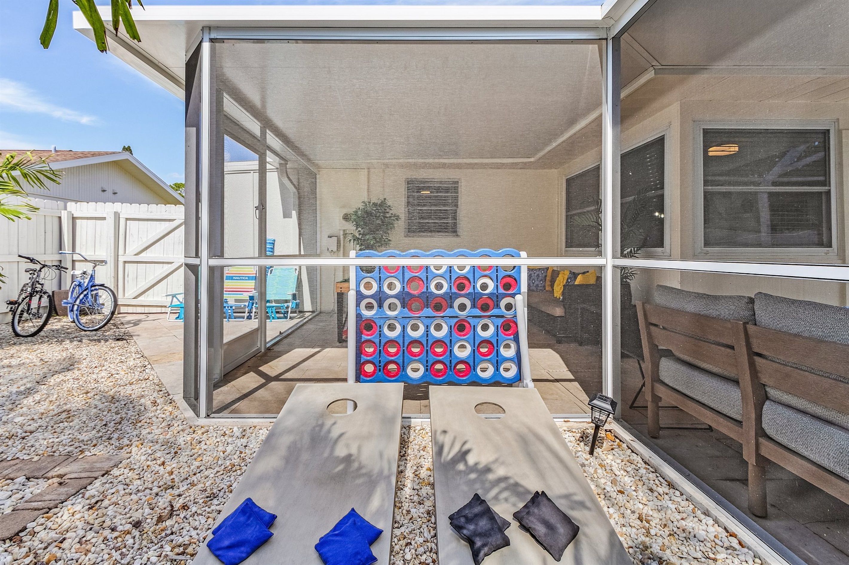 A screened porch with a pool table, outdoor seating, and a bicycle.
