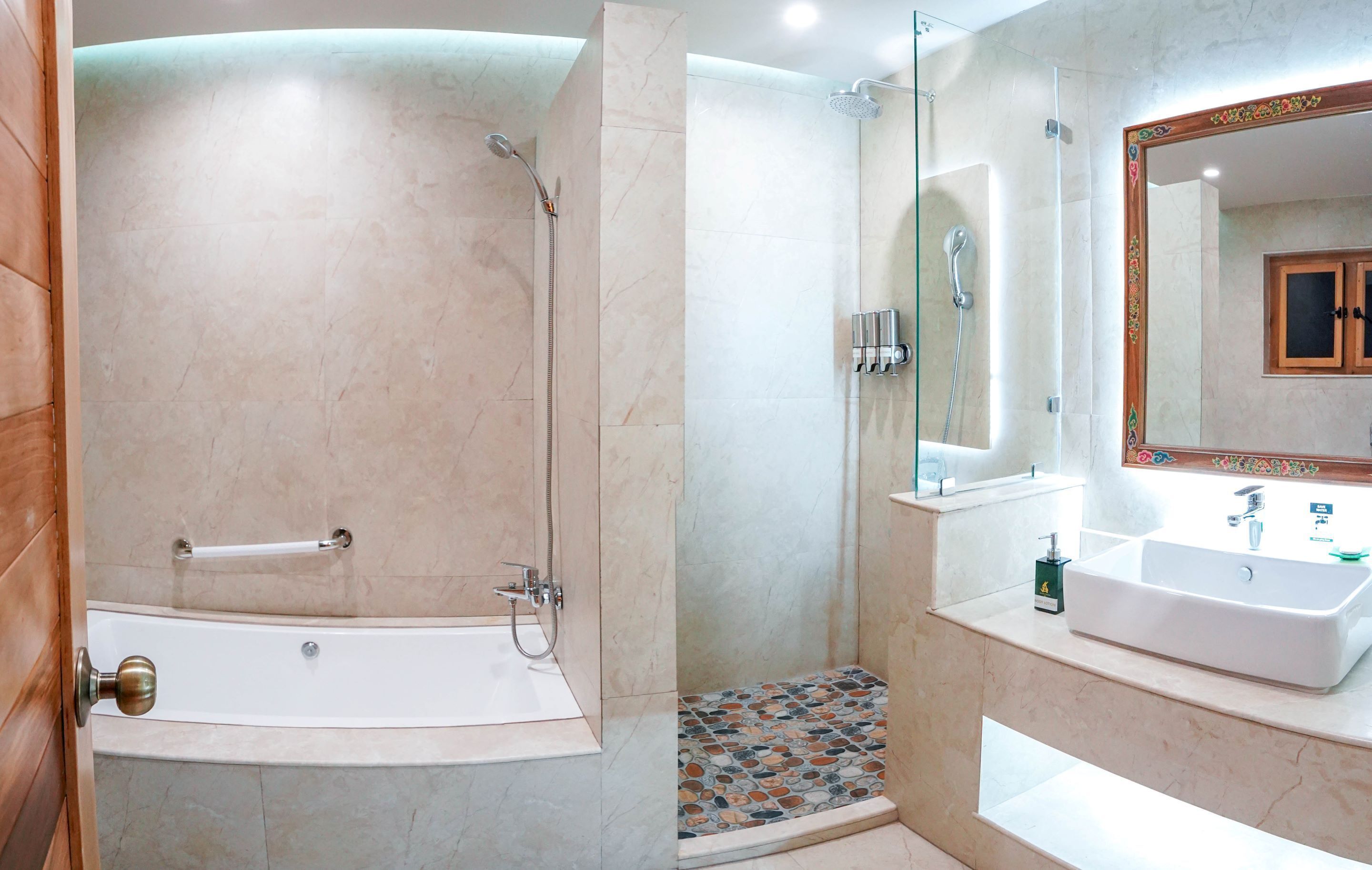 A modern bathroom with a bathtub, shower, and a vanity with a mirror.