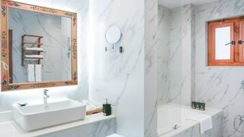 Un baño moderno con un espejo grande, dos lavamanos, una bañera y una ducha.