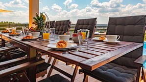 A wooden dining table set for breakfast with chairs, plates of food, and glasses of orange juice. - Stunning private villa for 8 people with A/C, private pool, WIFI, TV, terrace and pets allowed (Vodice)