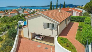 A modern two-story house with a red-tiled roof, a garage, and a paved driveway. - Stunning private villa for 8 people with A/C, private pool, WIFI, TV, terrace and pets allowed (Vodice)