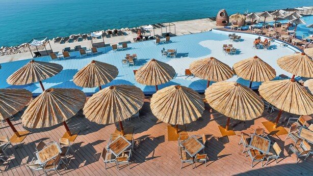 A resort pool area with sun loungers and umbrellas, surrounded by a scenic view of the sea and islands. - Stunning private villa for 8 people with A/C, private pool, WIFI, TV, terrace and pets allowed (Vodice)