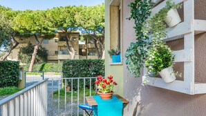 A balcony with a table, chairs, and potted plants. - Lovely apartment for 4 people with WIFI, A/C, TV, balcony and pets allowed (Cecina)