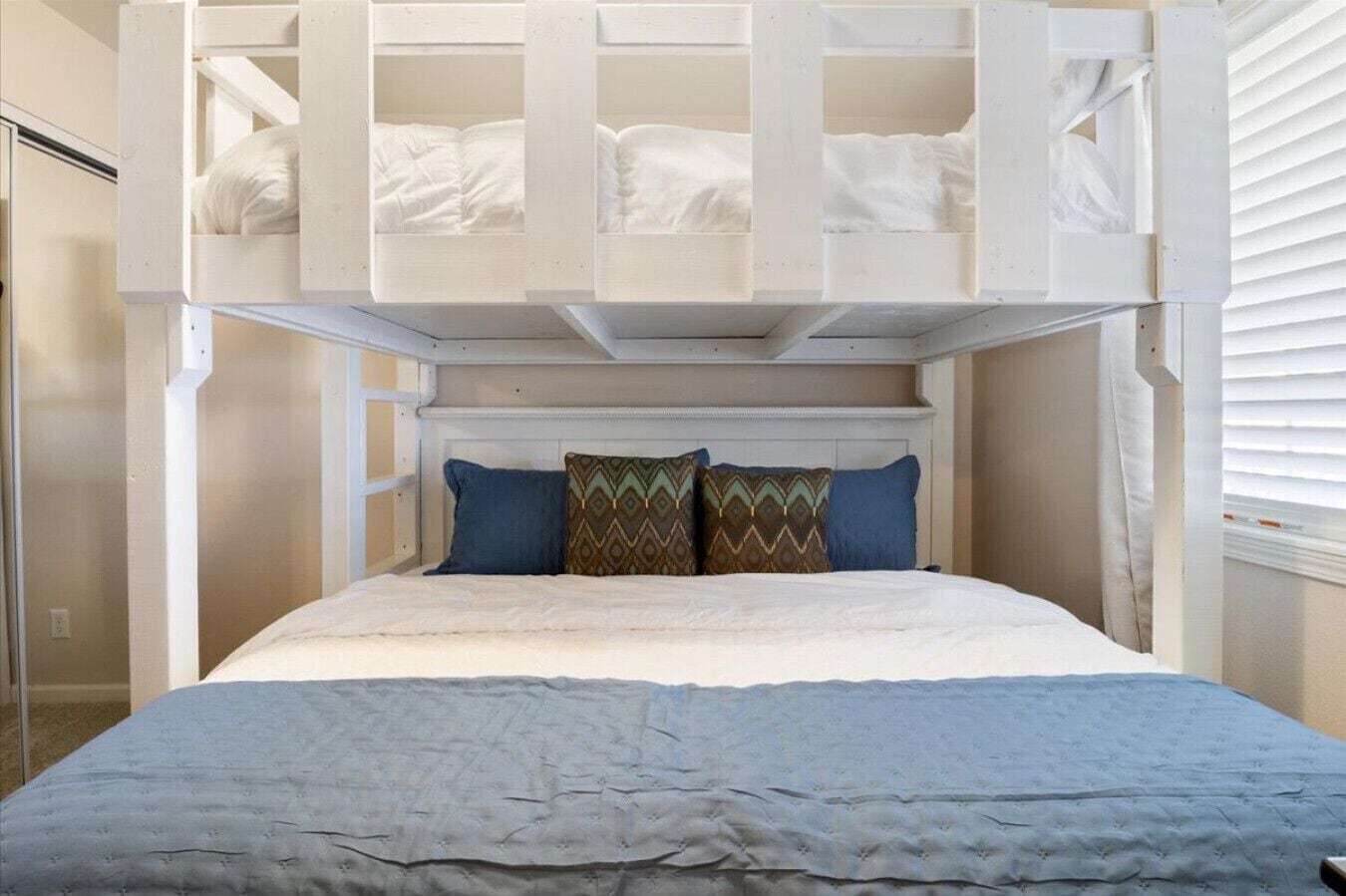 A bunk bed with a white headboard and two pillows.