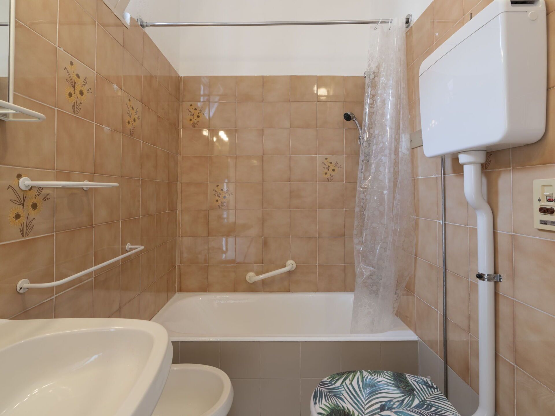 Une salle de bain avec une baignoire, des toilettes et un rideau de douche.