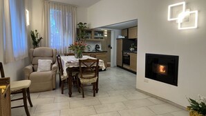 A modern living room with a fireplace, dining area, and kitchen. - Lovely apartment for 4 guests with WIFI, A/C, TV and patio (Costarainera)