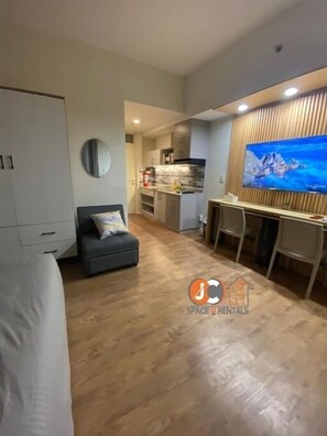 A modern apartment with a living area, kitchenette, and a dining space.