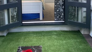 A bedroom with a bed, a window, and a door leading to a balcony. - Auckland City Private-Modern Downstairs Ensuite+Patio+secluded Garage in Parnell (Auckland)