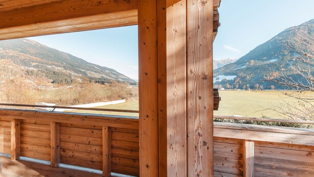 Eine Holzhütte mit Blick auf eine Berglandschaft.