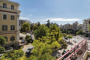 A cityscape with buildings, trees, and parked cars. - Liberty by halu! | 3 Bedroom Apartment in Thessaloniki Center (Thessaloniki)