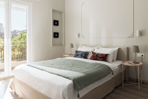 Un dormitorio con cama, dos mesitas de noche, una ventana y vistas al exterior.