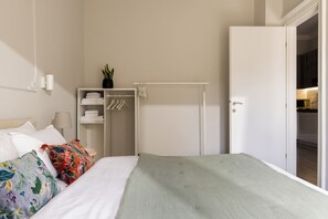 A bedroom with a bed, a wardrobe, and a door leading to a kitchen. - Liberty by halu! | 3 Bedroom Apartment in Thessaloniki Center (Thessaloniki)